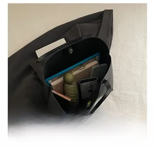 Detailed interior of black leather tote bag showing spacious capacity with personal items