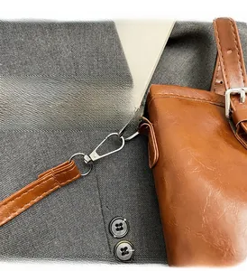 Close-up of durable silver metal hook and stitching on brown vintage leather bag
