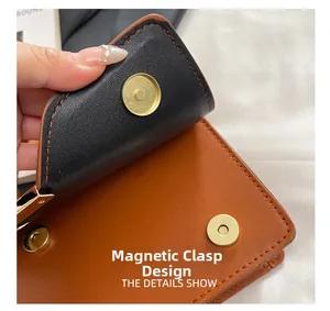 Detail des Magnetverschlusses an einer braunen Lederhandtasche mit Webmuster