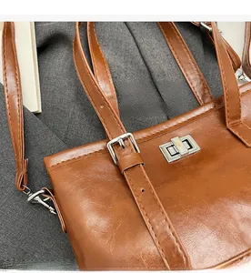 Detail of vintage brown tote bag featuring silver square twist lock and smooth wax leather