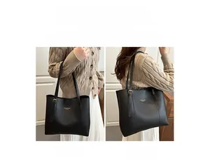 Close-up of black leather tote bag showing textured finish and dual carrying styles
