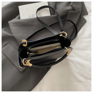 Interior view of black leather handbag showing space for a large phone and a long wallet