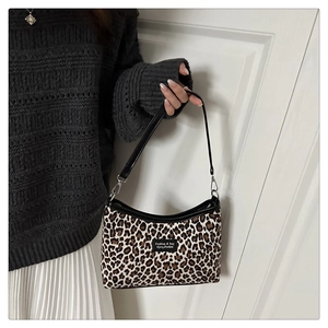 Detail of leopard print handbag showing the textured fabric and black brand label