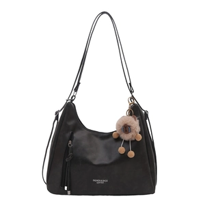 Large black matte shoulder bag with a plush capybara charm and side tassel pocket