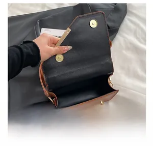 Detailansicht der braunen Ledertasche mit Magnetverschluss und goldenen Metallkanten
