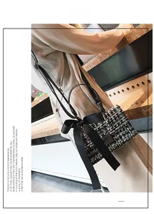 Detail of tweed crossbody bag with large satin bow and metallic square buckle on a model