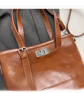 Detail of vintage dark brown tote with pleated leather texture and silver twist lock