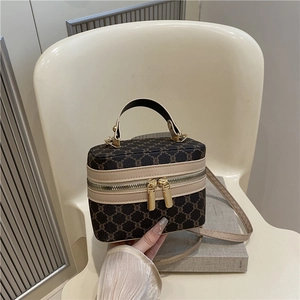 Vintage patterned crossbody box bag with dual zippers and leather handle on a chair