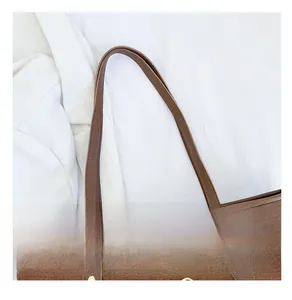 Détail du sac cabas en daim marron avec bandoulières en cuir renforcées et rivets