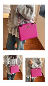 Détail du sac à main rose en cuir grainé avec logo métallique en forme de V doré