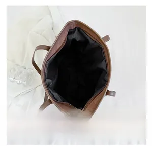 Vue détaillée du haut du sac cabas marron avec compartiment spacieux et fermeture éclair