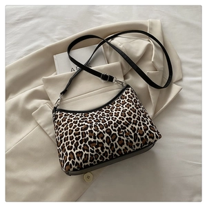 Close-up of leopard print tote bag with black leather straps and silver metal hardware