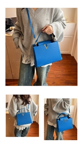Vue détaillée du logo en V métallique et du cuir bleu grainé de ce sac à main