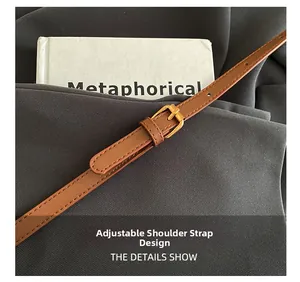 Détail d'une bandoulière réglable en cuir marron avec boucle en métal doré pour sac