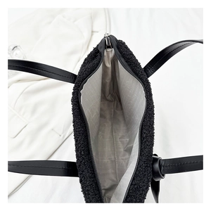 Close-up of black fuzzy bucket bag interior with gray wave liner and smooth zipper closure