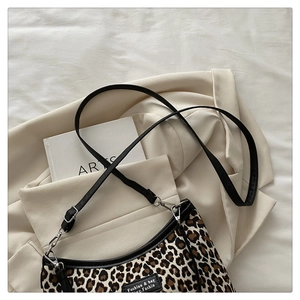 Detailed view of leopard print tote with black trim and detachable shoulder strap
