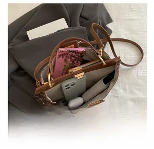 Détail de l'intérieur spacieux du sac seau vintage marron avec divers objets quotidiens