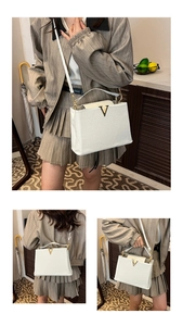 Détail du sac à main en cuir grainé blanc avec logo V doré et bandoulière amovible