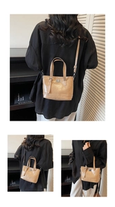 Detail view of khaki tote bag with silver twist lock and adjustable shoulder strap