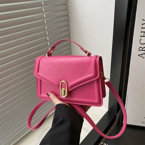 Magenta minimalist leather crossbody bag with golden twist lock and top handle