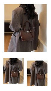 Detailed view of deep brown vintage bucket bag with silver turn-lock and leather handles