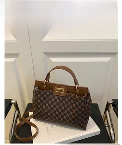 Vue détaillée du grand sac vintage avec imprimé et fermoir pivotant en métal doré