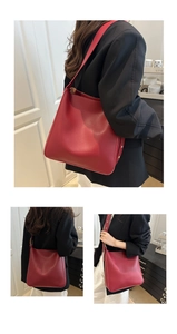 Detail of red leather bucket bag featuring gold rivets and spacious tote interior