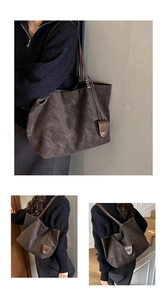 Macro view of the dark brown tote bag showing textured matte finish and long shoulder straps