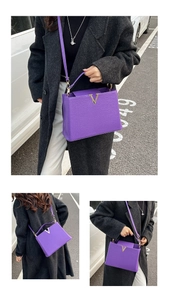 Détail du sac à main violet motif litchi avec boucle en V dorée et bandoulière chic