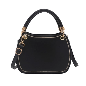 Minimalist black velvet handbag with golden circular hardware and adjustable strap