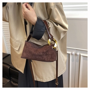 Detail of vintage brown suede tote bag with gold chain and crossbody strap handle