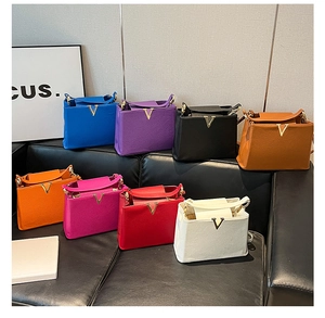 Détail de sacs à main en cuir de huit couleurs avec ornement métallique doré en forme de V