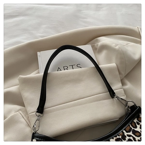 Close-up of leopard print underarm bag with black leather trim and silver metal hardware