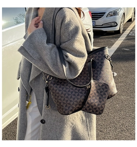 Detailed view of tote bag set with geometric patterns and leather handles on model
