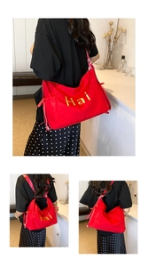 Macro detail of red nylon tote bag featuring yellow Hai embroidery and side drawstring