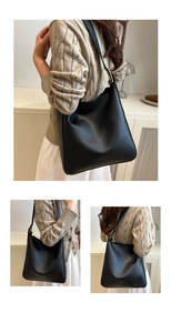 Detail view of black leather tote bag showing adjustable gold buckle and smooth texture