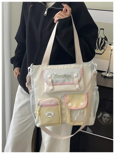 Detail of multi-pocket nylon tote bag with pastel color-block design and dual straps