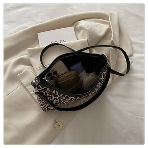 Detailed internal capacity of leopard print tote bag holding makeup and smartphone