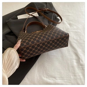 Détail du sac seau vintage avec motif monogramme classique et finitions en métal doré