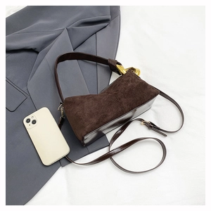 Detailed top view of a dark brown suede rectangular crossbody bag with gold-tone hardware