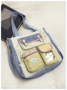 Detail of color-block bucket bag with functional pockets and contrast straps