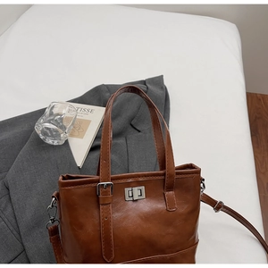 Detailed view of brown quilted retro tote bag with silver metal twist lock and straps