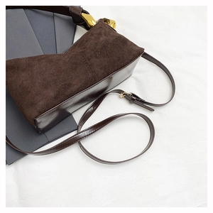 Detail of dark coffee vintage shoulder bag featuring suede texture and gold hardware