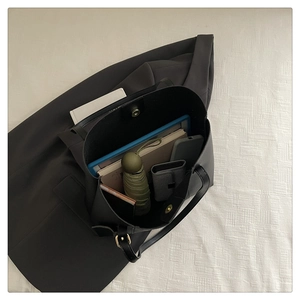 Spacious black tote bag showing interior storage for tablets, books, and daily essentials