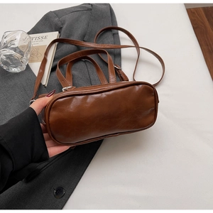 Detailed view of the brown retro crossbody bag with premium leather texture and hardware