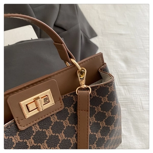 Détail du sac seau vintage avec garniture en cuir marron et fermoir doré élégant