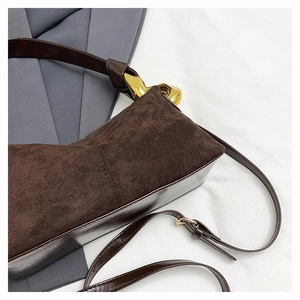 Macro shot of dark brown suede stitching and glossy leather with golden metal hardware