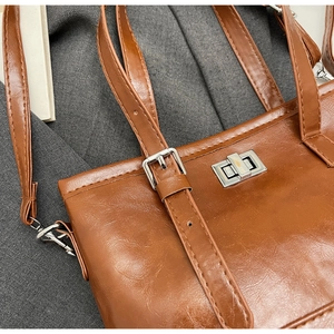 Close-up of caramel leather bag featuring a silver metal turn-lock and fine grain texture
