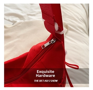 Detail shot of the red nylon tote bag featuring a smooth silver metal zipper close-up