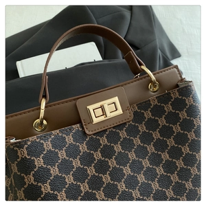 Gros plan du sac seau vintage avec motif monogramme marron et fermoir pivotant doré
